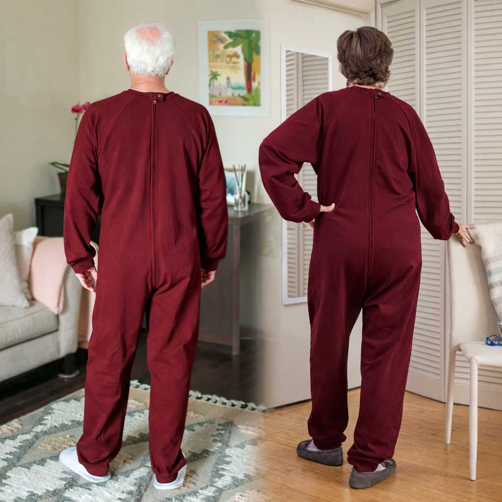 Two people wearing burgundy dementia onesies in a home setting faced backwards.