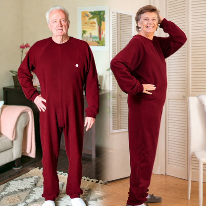 Two people wearing matching burgundy anti strip jumpsuits in a living room setting.