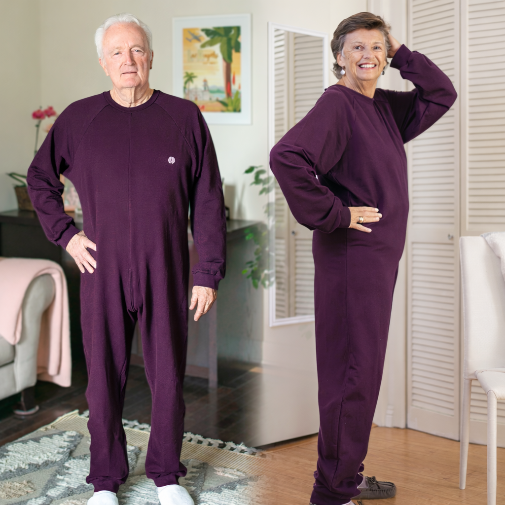 Two people wearing purple dementia jumpsuits in a living room.