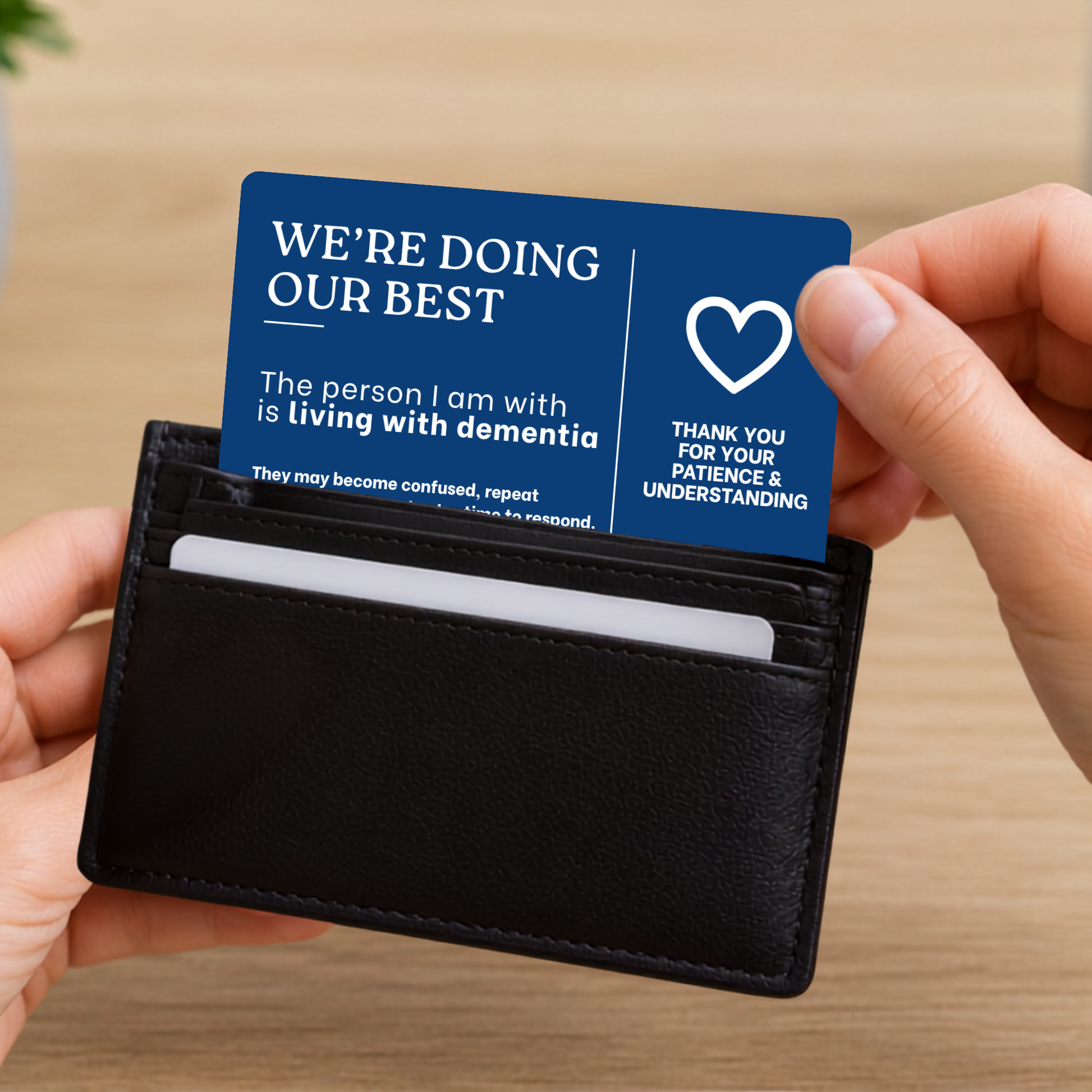 Person holding a black wallet with a blue card about dementia support.